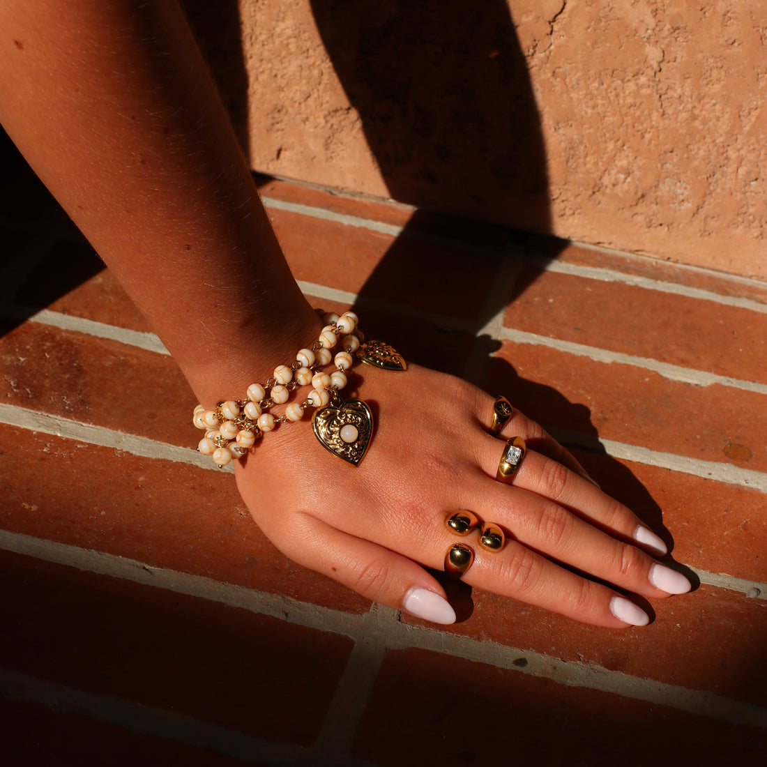 Bracelet Elena à perles avec pendentif cœur porté au poignet – Rélia Bijoux