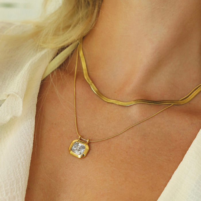 Jeune femme portant un collier à pendentif solitaire doré en acier inoxydable 304, idée cadeau de naissance Rélia Bijoux